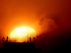 荒川からサンシャインビルの屋上の雲被る夕日