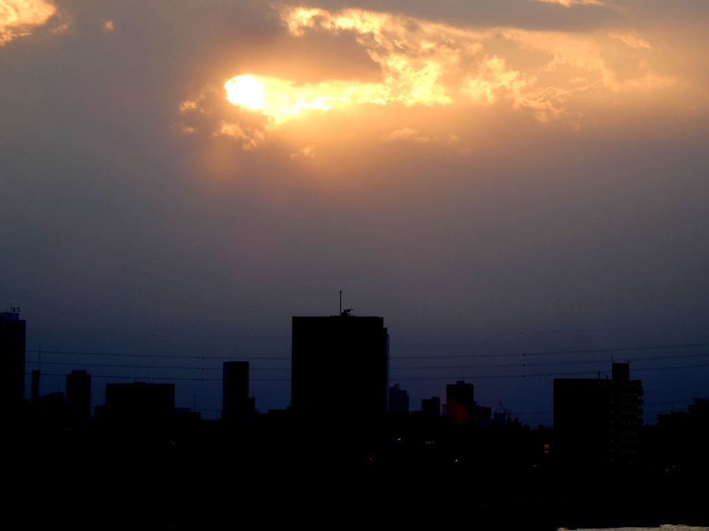 荒川の雲間の夕日
