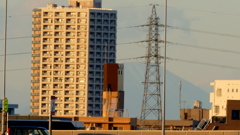 荒川土手から高速の上の鉄塔の後ろに見える日光男体山