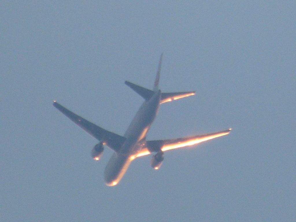 上空の夕日を浴びる飛行機