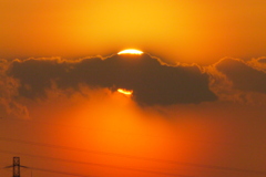 ベールを被った夕日に黒雲掛かる