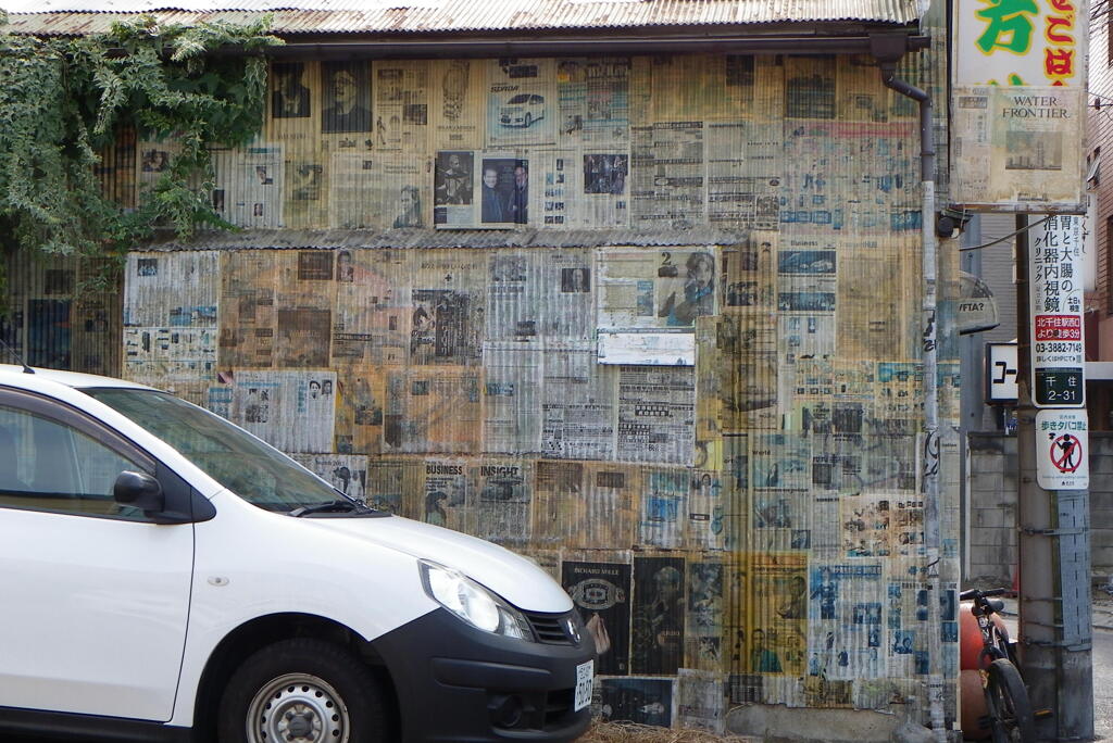 千住の駐車場隣のトタン屋根の新聞サイデイング