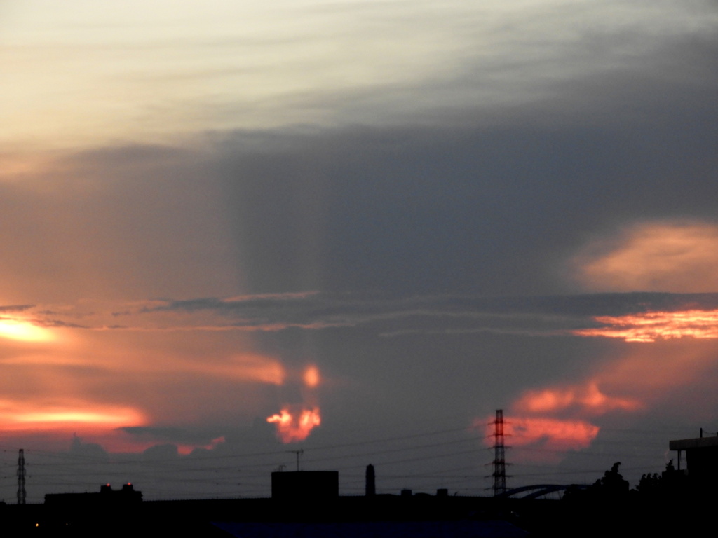 隅田川の夕日が落ちたかなとこ雲から漏れる強い薄明光線