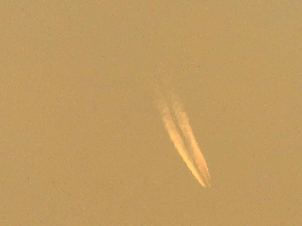 夕日の遠くの飛行機雲
