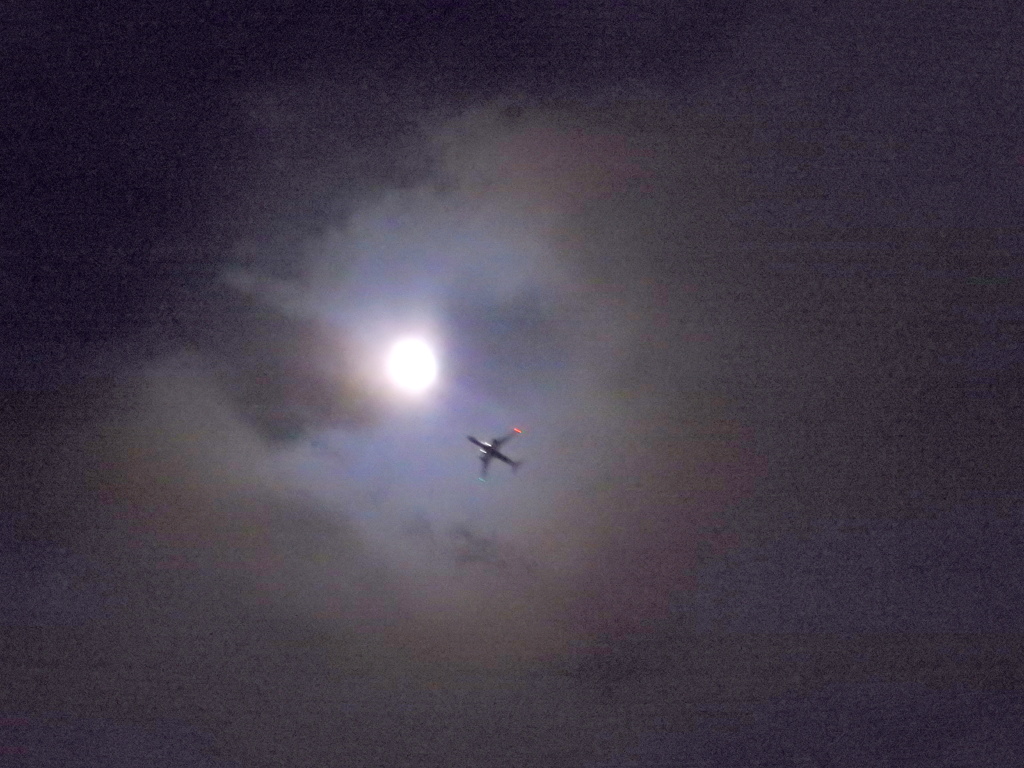 雲間の月齢10.2のつきと航空機
