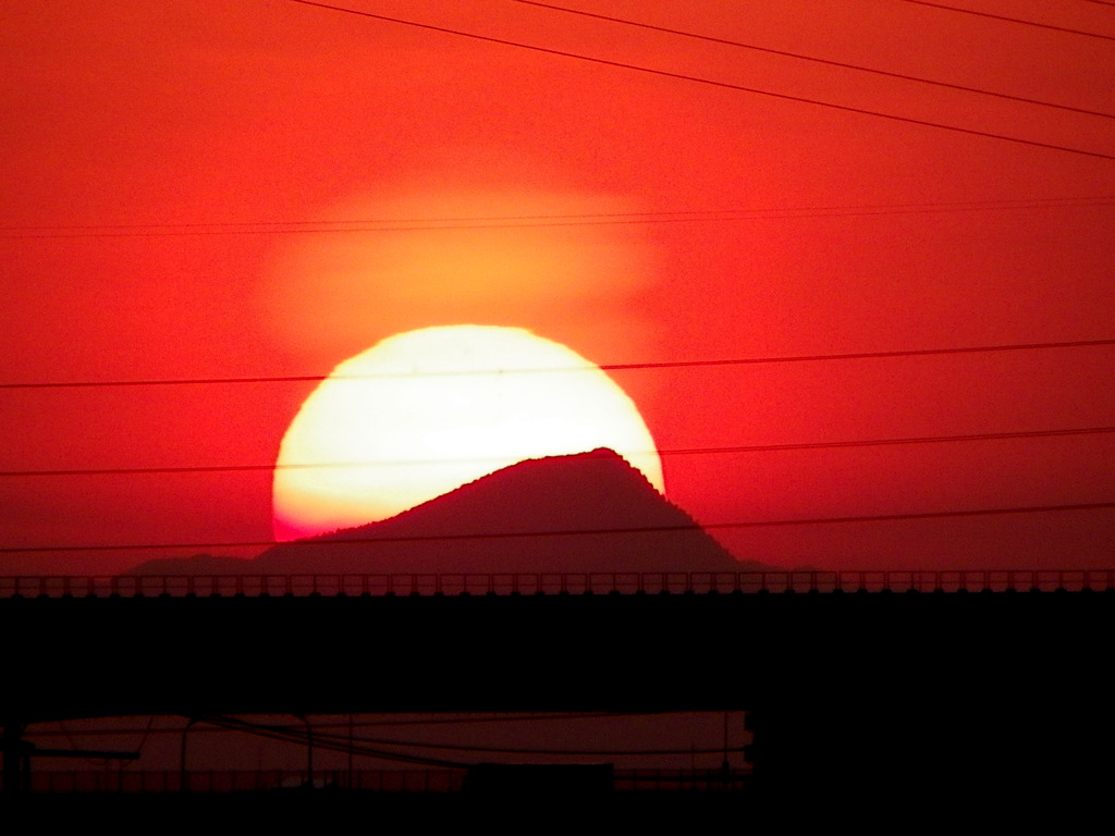武甲山の山頂に掛かる大きな黄色いホヤのある夕日