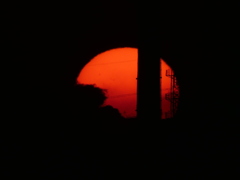 煙突に沈む真っ赤な夕日
