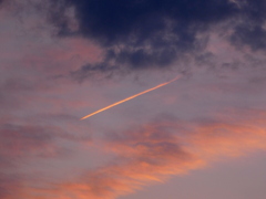 雲の中に入る夕日の上空の夕焼雲