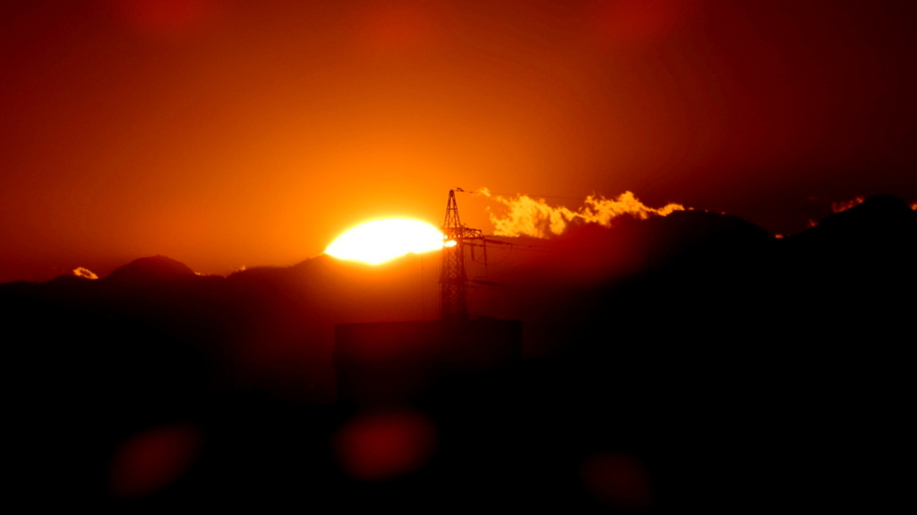 雲の晴れた丹沢山系の鉄塔やや左の夕日