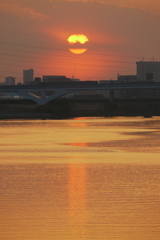 雲被る夕日の反映の荒川