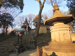 上野の時の鐘の前の夕日を浴びる石灯籠と上野大佛