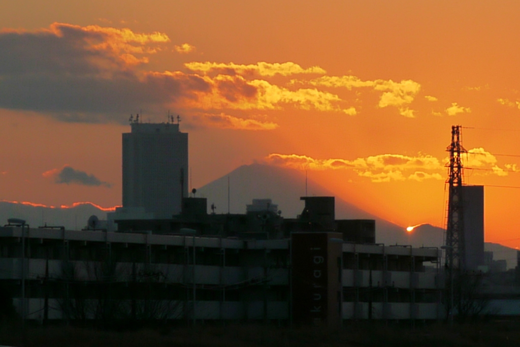 富士山と大室山の谷に消える夕日と富士山から左上に伸びる影富士