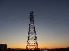 荒川の河原に立つ鉄塔の夕焼け