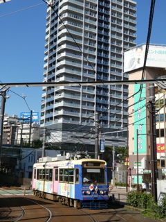 古風な電車と近代的な高層マンション