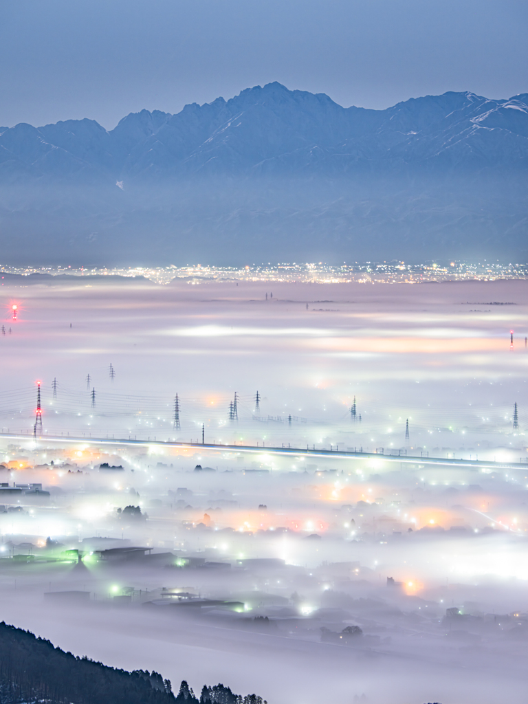 雲海に灯る街並みと立山連峰