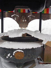 雪に覆われた香炉と布袋様