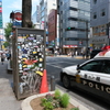 渋谷の電話ボックスとパトカーと警察官の腕