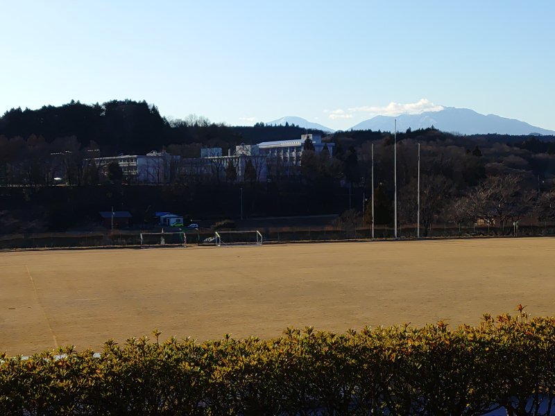 芝生の奥の校舎と山（12月28日）