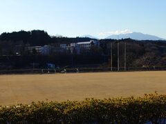 芝生の奥の校舎と山（12月28日）