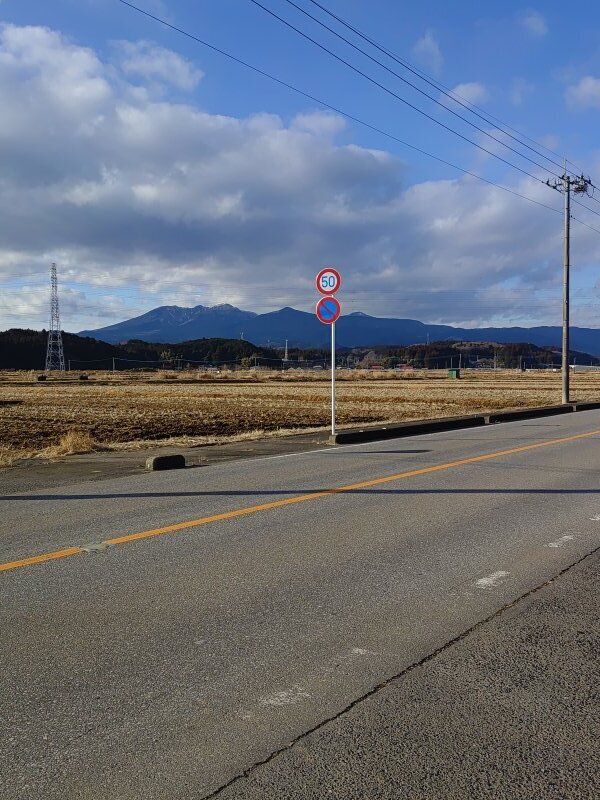 標識と電柱の奥にある高原山（1月4日）