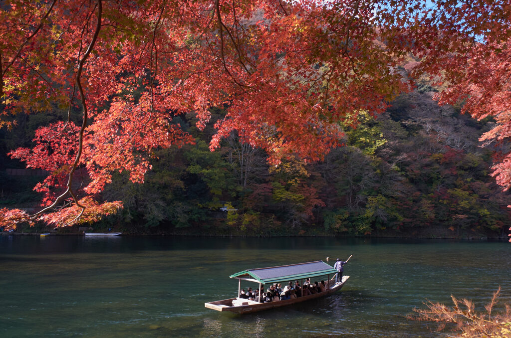 渡月橋上流の紅葉と舟