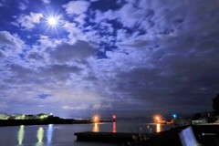雲間の月に照らされる田子の浦