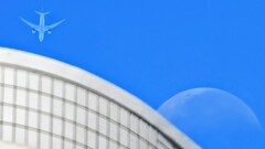 マンションと下弦の月と旅客機。