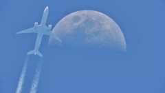 上弦の月と旅客機