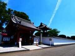 山門と鐘楼と飛行機雲