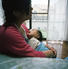 昼寝の孫を抱きかかえる次女