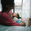 昼寝の孫を抱きかかえる次女