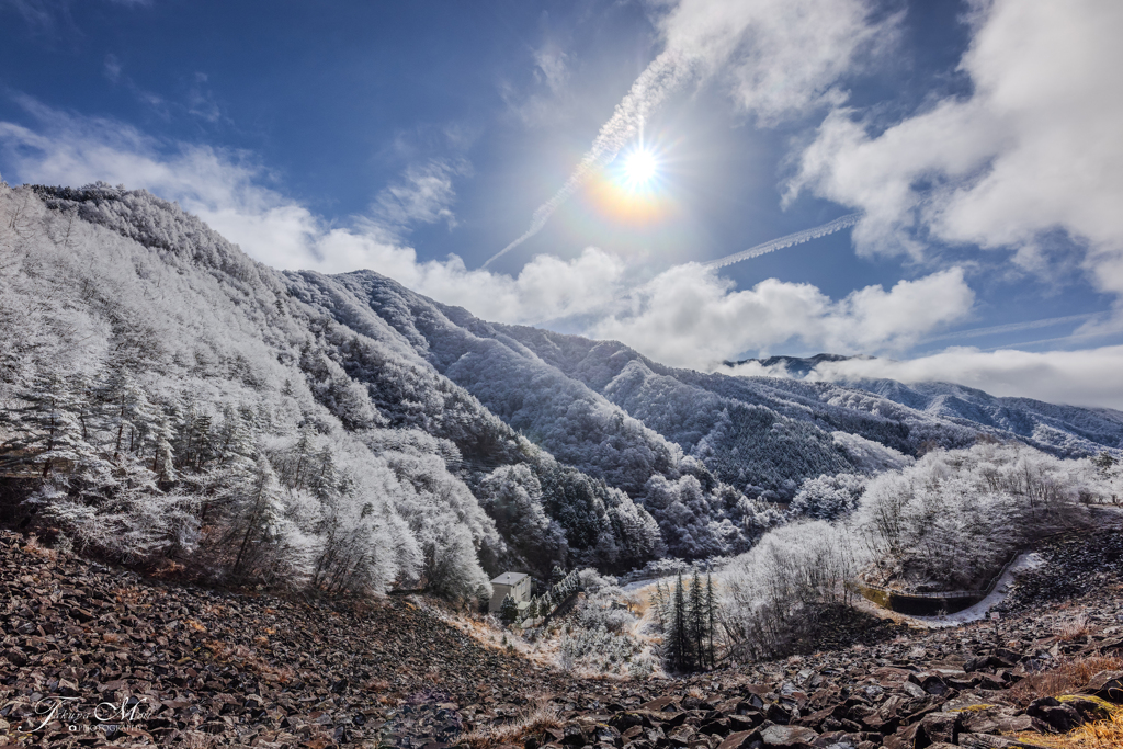 雪化粧した山と光環