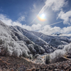 雪化粧した山と光環