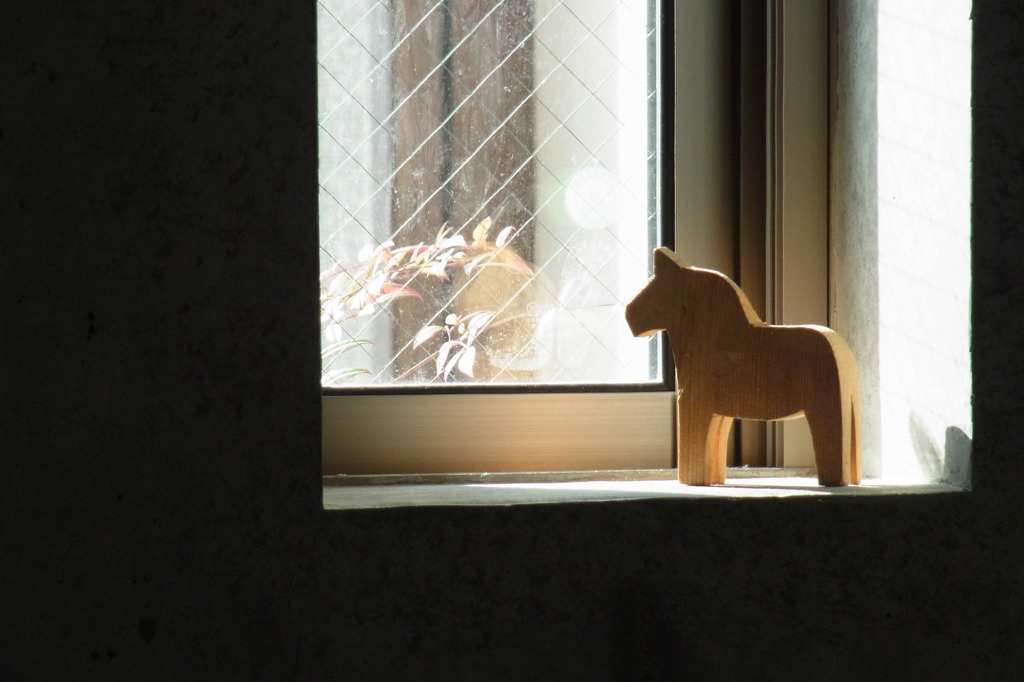 窓際で外を眺める休日の馬