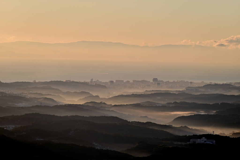 朝靄の丘陵と市街地