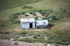 牧草地の放牧小屋と子どもたち