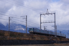 雪化粧した比良山の麓を走る電車