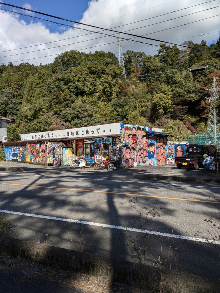 外観に顔の絵だらけの、しかも壁に謎の信号機があるお店