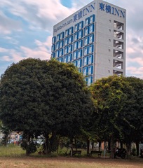 秋の公園とビジネスホテル