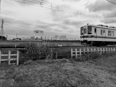 工場地帯を背景に疾走する電車