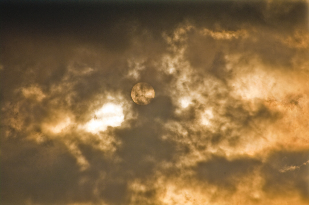 雲に霞む夕日