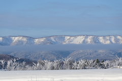 「川霧と雪の山並み」