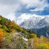 積雪の明神岳と上高地の紅葉