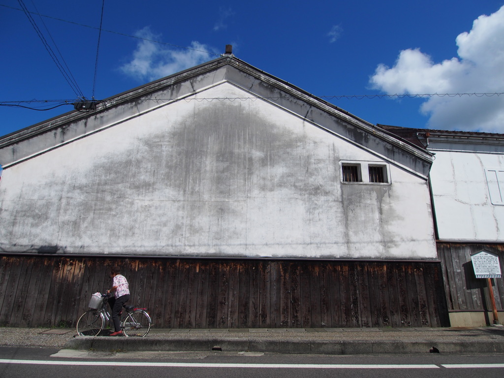 白壁と自転車こいでる人