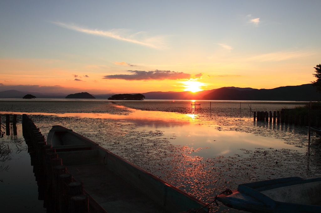 びわ湖に浮かぶ小船と夕焼け