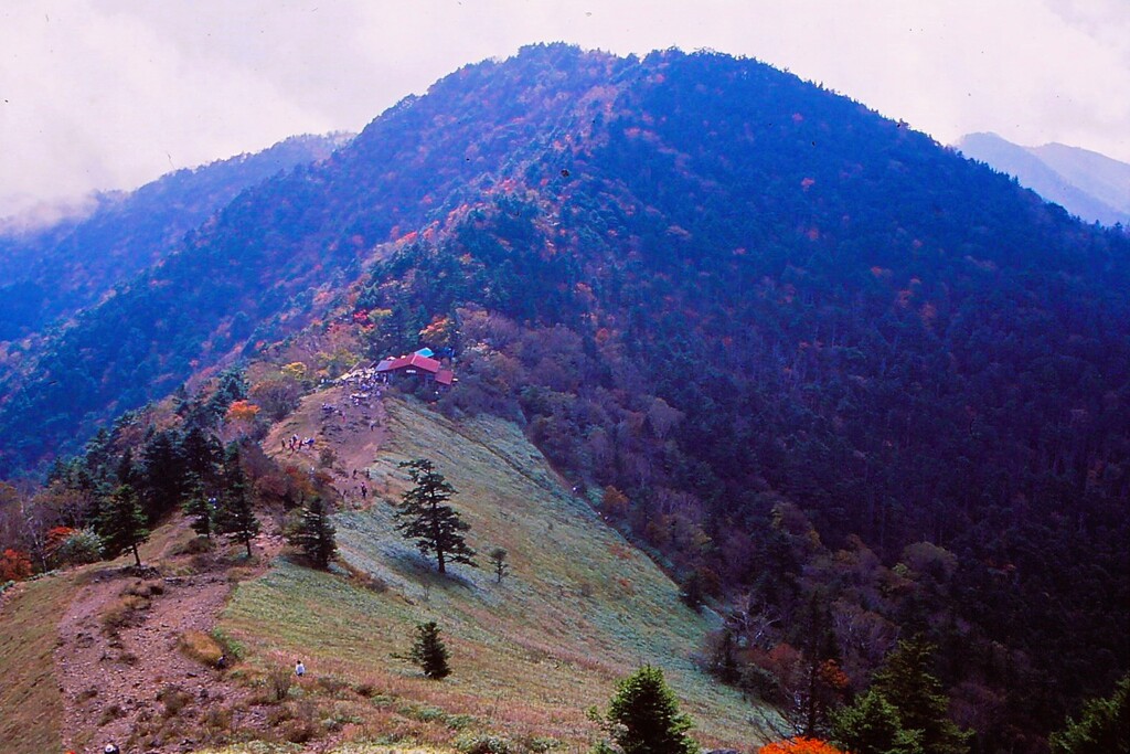 秋色に染まる山稜と山小屋