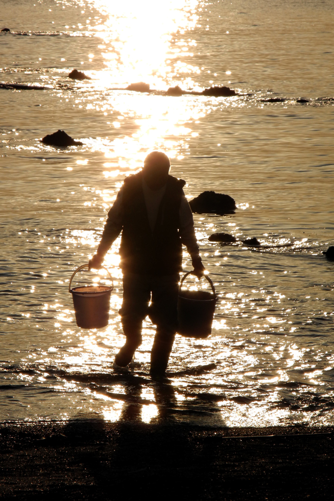 海水を汲む漁師