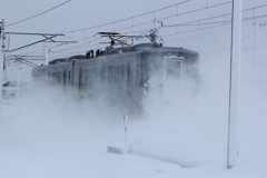 雪煙の中へ消えていく