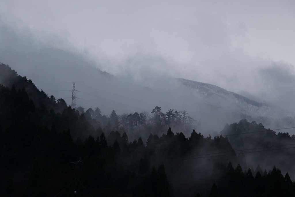 煙る山