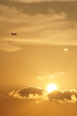 夕焼けに消え行く飛行機